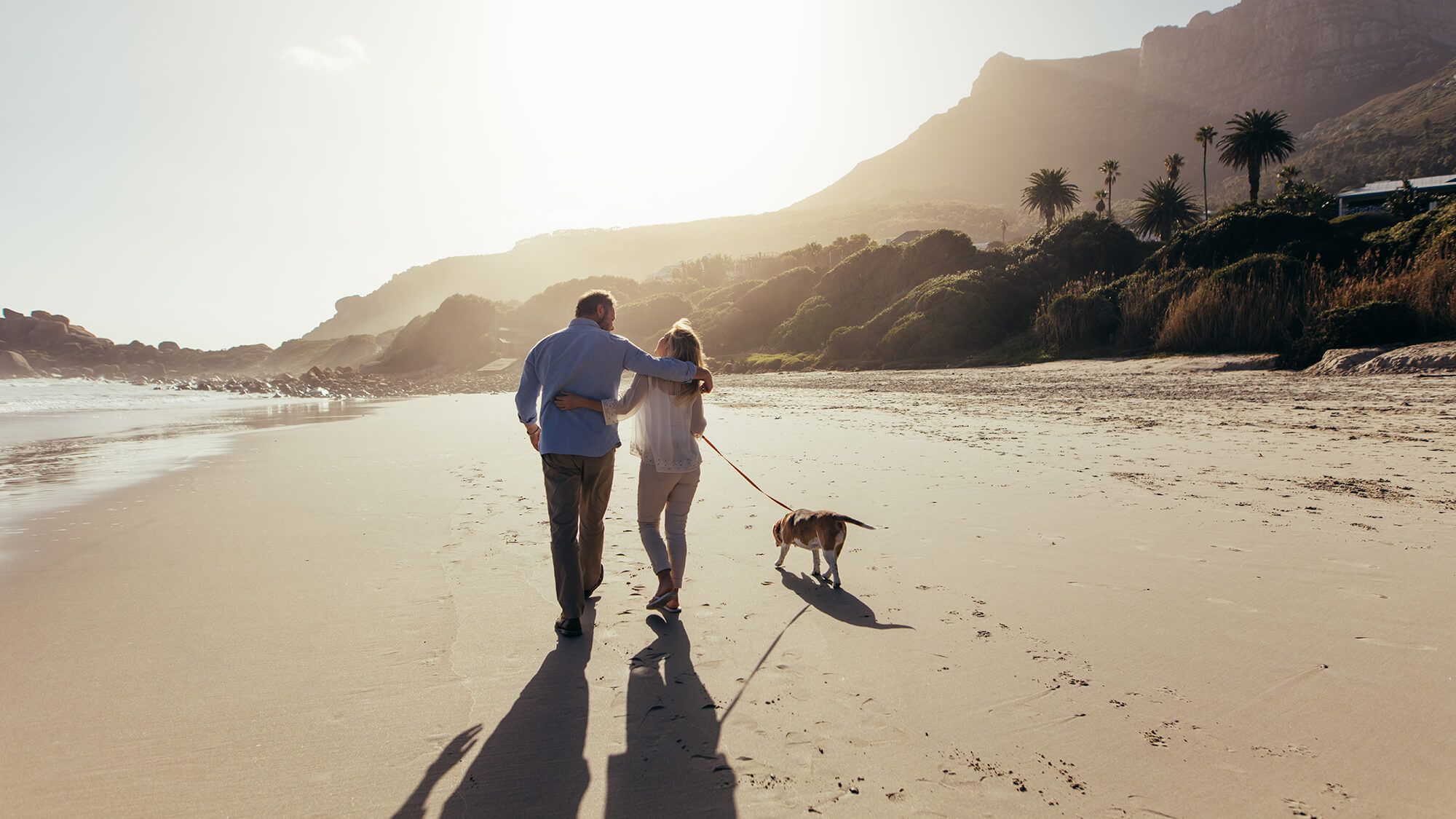 Older couple walking on beach